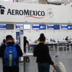 Passengers wait in line at an Aeromexico check in counter