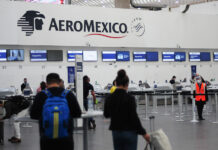 Passengers wait in line at an Aeromexico check in counter