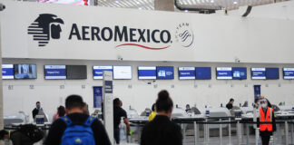 Passengers wait in line at an Aeromexico check in counter