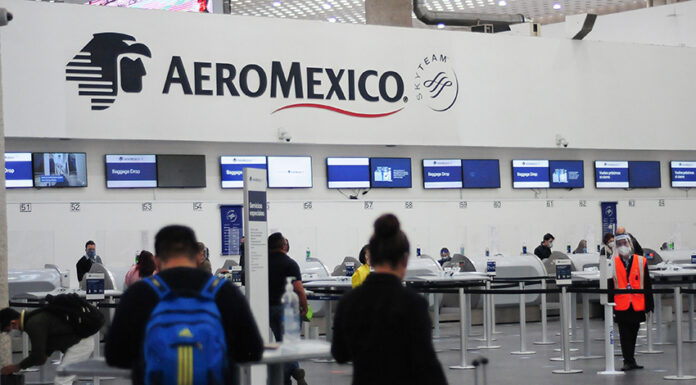Passengers wait in line at an Aeromexico check in counter