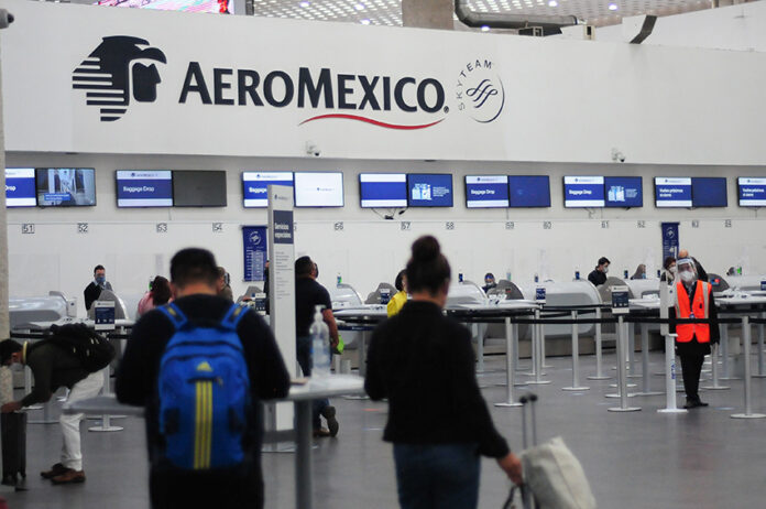 Passengers wait in line at an Aeromexico check in counter