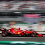 A Formula 1 race car speeds through an out-of-focus stadium in Mexico City