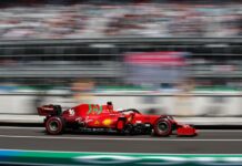 A Formula 1 race car speeds through an out-of-focus stadium in Mexico City