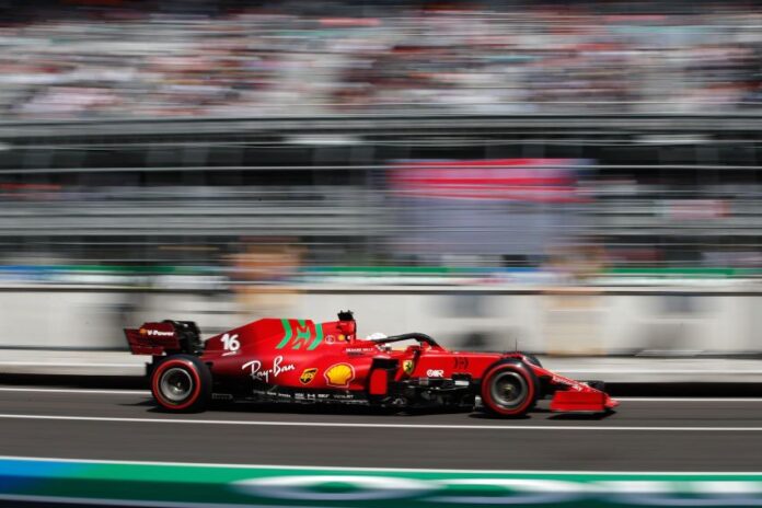 A Formula 1 race car speeds through an out-of-focus stadium in Mexico City