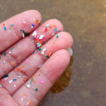 Fingers covered in small pieces of plastic