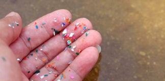 Fingers covered in small pieces of plastic