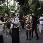 Pairs of middle-aged Mexican couples dancing in a public park in Mexico City.