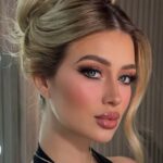 A blond influencer with doll-like makeup