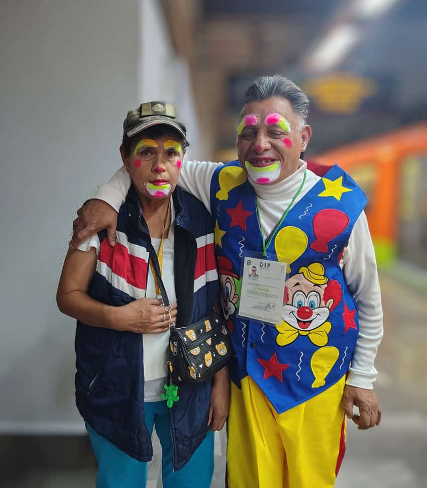 Two clowns pose for a photo in the Mexico City Metro