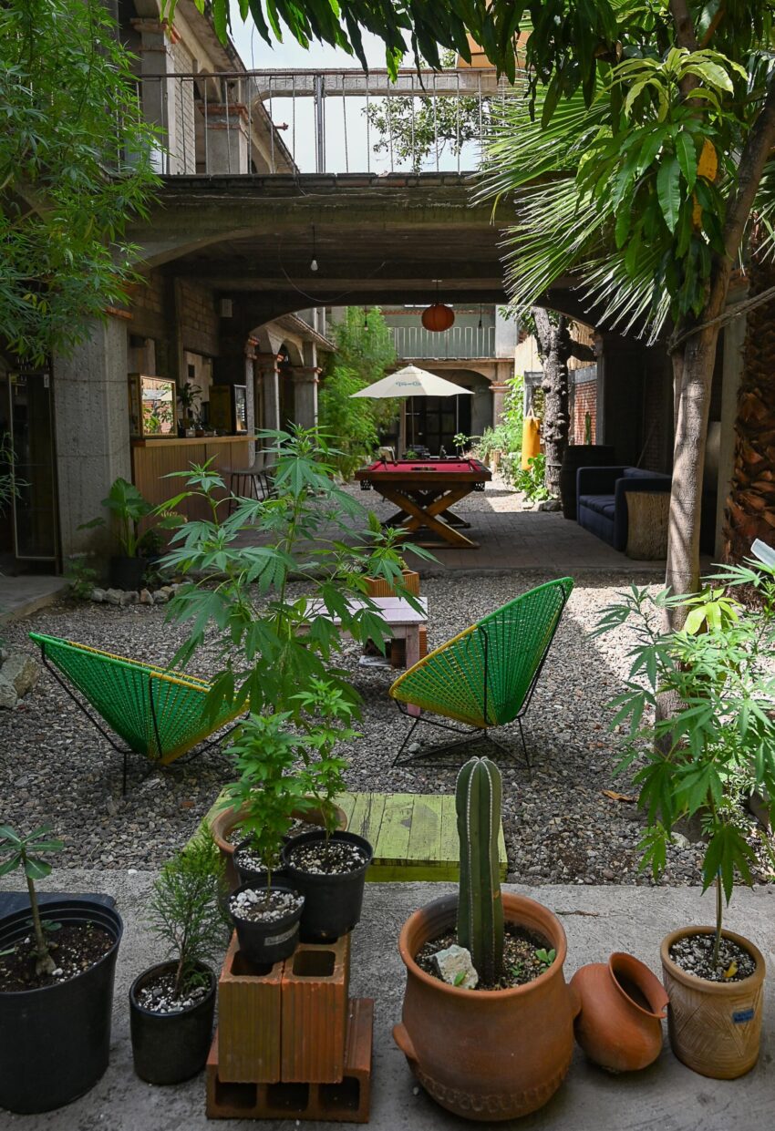 A courtyard in Oaxaca city with seating. The courtyard has stone arches in the distance.