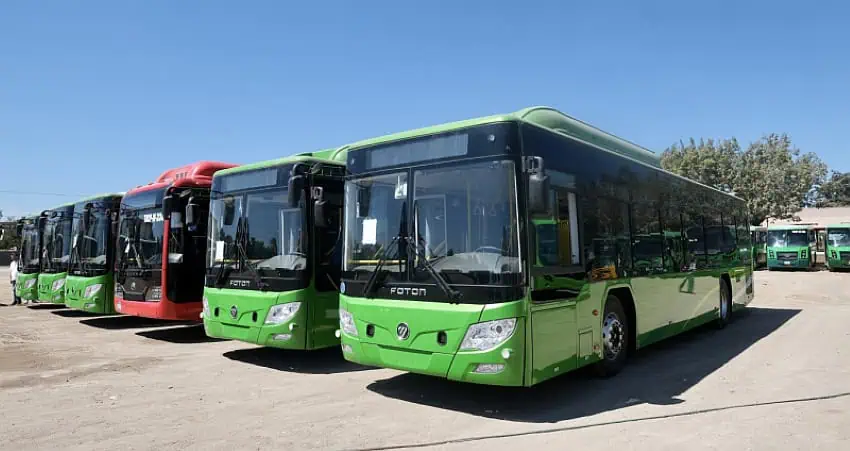 Green natural gas buses parked in a row in a bus depot in Mexico.