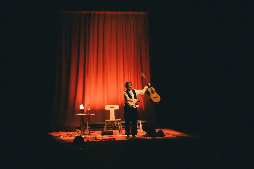 Natalia Lafourcade stands onstage at a Cancionera concert, holding a guitar