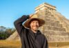 Young man with hat in front of a pyramid in Mexico