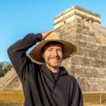 Young man with hat in front of a pyramid in Mexico