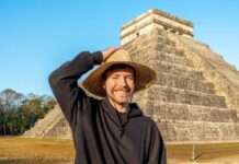 Young man with hat in front of a pyramid in Mexico