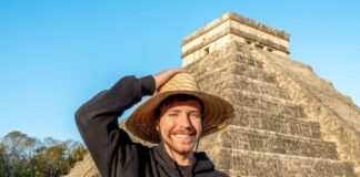 Young man with hat in front of a pyramid in Mexico