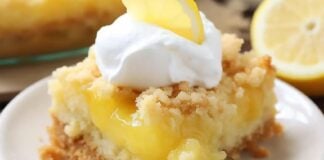 A slice of lemon cake with whipped cream and a fork