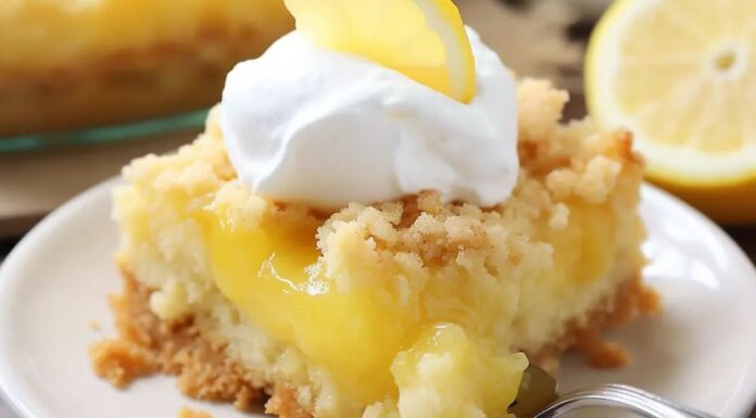 A slice of lemon cake with whipped cream and a fork