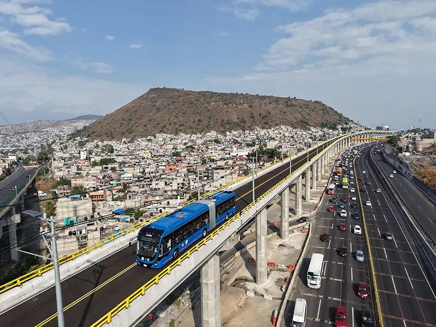 A blue trolpus backdrop on the backdrop of the urban Mexico city that runs over the highway over the highway