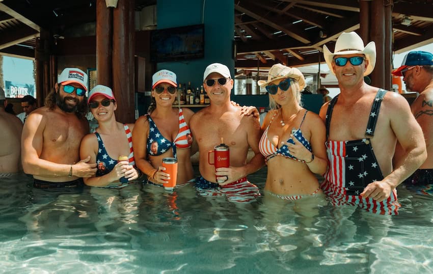 A group of men and women drinking alcohol in a pool