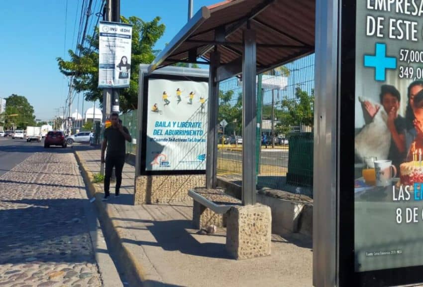 Man talking on a phone at a bus stop in Puerto Vallarta