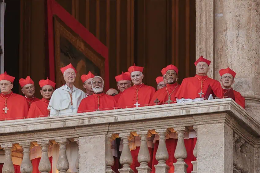 Catholic cardinals in red and white gather on a balcony