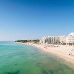 A white sand beach with turquoise water and condo towers in the Riviera Maya