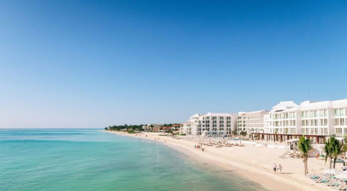 A white sand beach with turquoise water and condo towers in the Riviera Maya