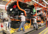 Factory workers assemble a car