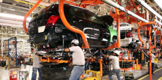 Factory workers assemble a car