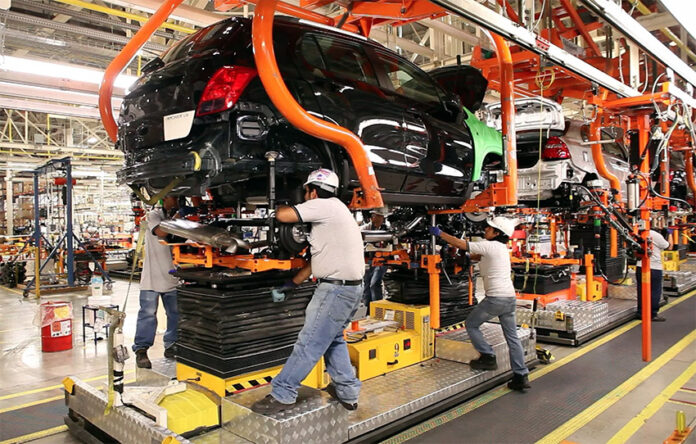 Factory workers assemble a car