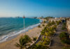 A view from high up over a beach of Puerto Vallarta's coastline and the various hotels and other buildings that ring the coast.