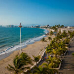A view from high up over a beach of Puerto Vallarta's coastline and the various hotels and other buildings that ring the coast.