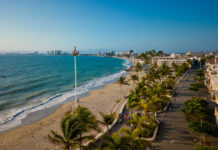 A view from high up over a beach of Puerto Vallarta's coastline and the various hotels and other buildings that ring the coast.