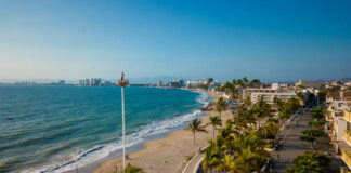 A view from high up over a beach of Puerto Vallarta's coastline and the various hotels and other buildings that ring the coast.
