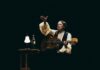 Natalia Lafourcade seated onstage with guitar during Cancionera tour