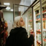 Woman opens a fridge in a convenience store