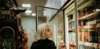 Woman opens a fridge in a convenience store