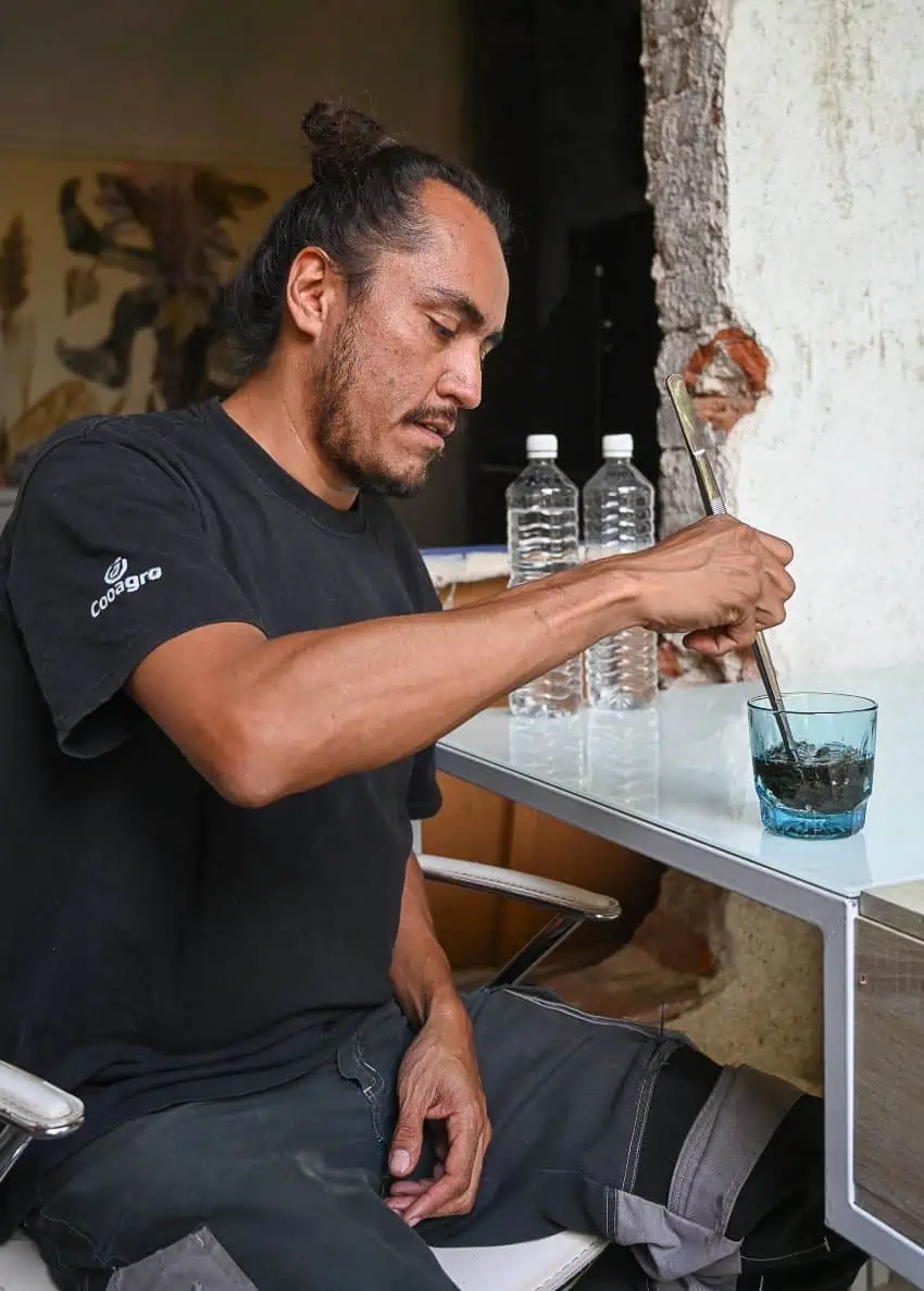 Seated man stirs a drink
