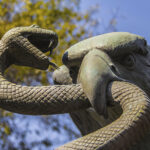 A sculpture depicts an eagle devouring a snake atop a nopal cactus, as seen on Mexico's national coat of arms.