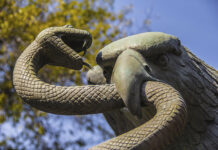 A sculpture depicts an eagle devouring a snake atop a nopal cactus, as seen on Mexico's national coat of arms.