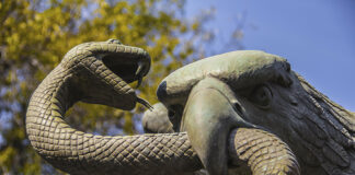 A sculpture depicts an eagle devouring a snake atop a nopal cactus, as seen on Mexico's national coat of arms.