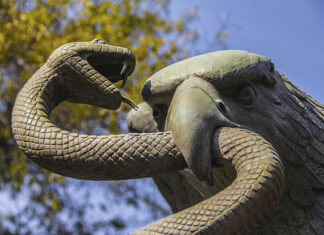 A sculpture depicts an eagle devouring a snake atop a nopal cactus, as seen on Mexico's national coat of arms.