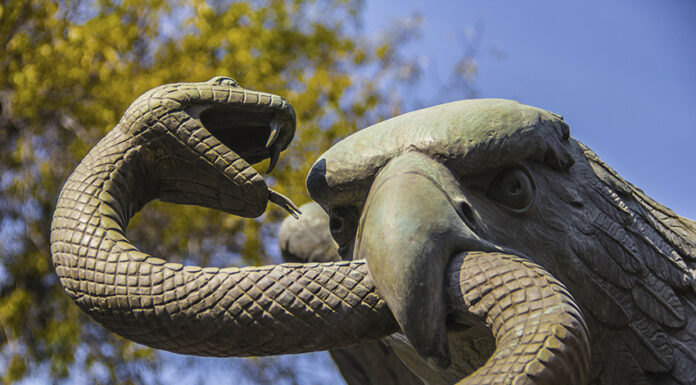 A sculpture depicts an eagle devouring a snake atop a nopal cactus, as seen on Mexico's national coat of arms.