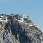 A luxury house on a cliff overlooks the Pacific ocean.