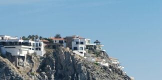A luxury house on a cliff overlooks the Pacific ocean.