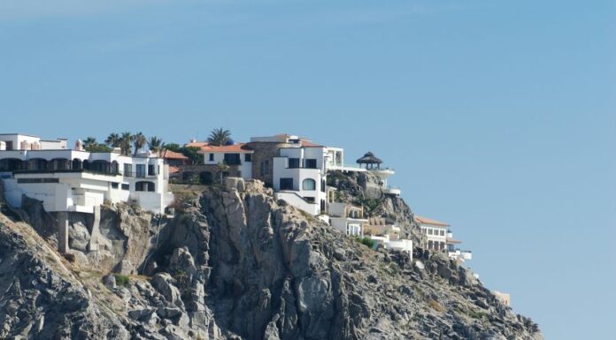 A luxury house on a cliff overlooks the Pacific ocean.