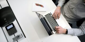 A person sitting at a desk with a laptop and coffee
