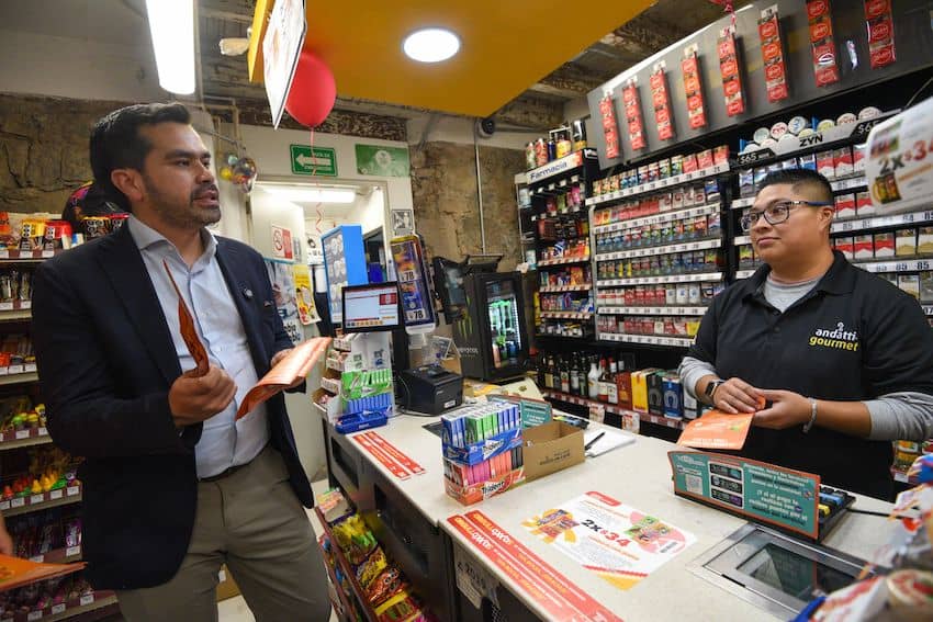 Former presidential candidate Jorge Álvarez Maynez speaks to a worker at an Oxxo in Toluca, México state, about the new Chair Law.