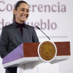 President Sheinbaum stands behind a podium at her morning press conference